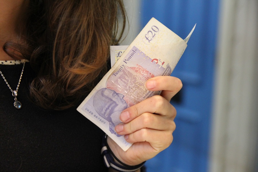 Woman holding £20 notes