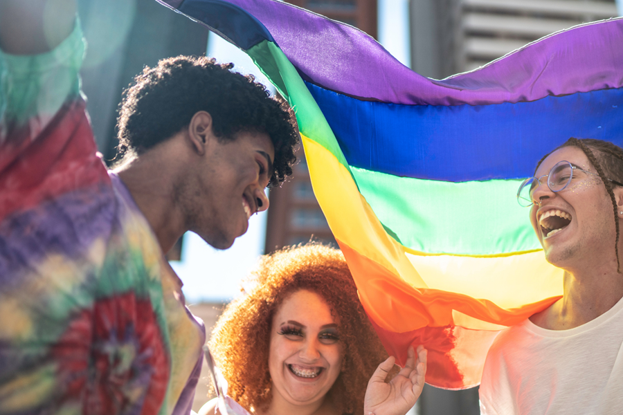 Three people with PRIDE flag