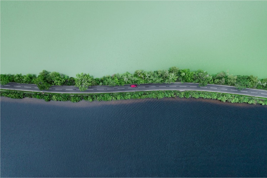 Car moving between dark and light lakes in Scotland