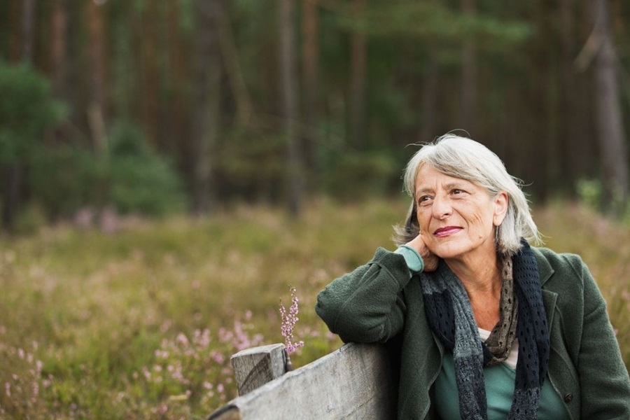 Grey haired woman on park bench