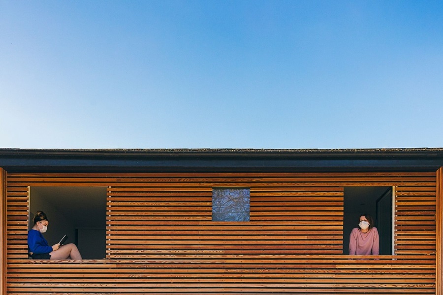 Young and old divide in house against blue sky