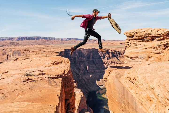 Man jumping a canyon reflecting bridging the gap between brand and CX