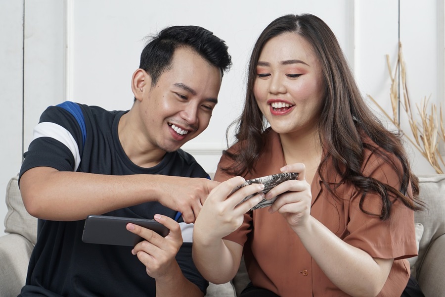 Young couple playing mobile game
