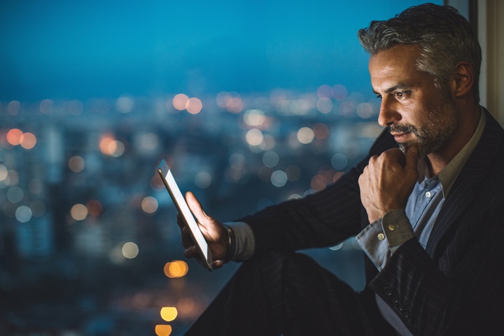 Man sat in a window checking his phone