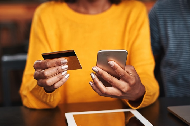 person with credit card and mobile phone