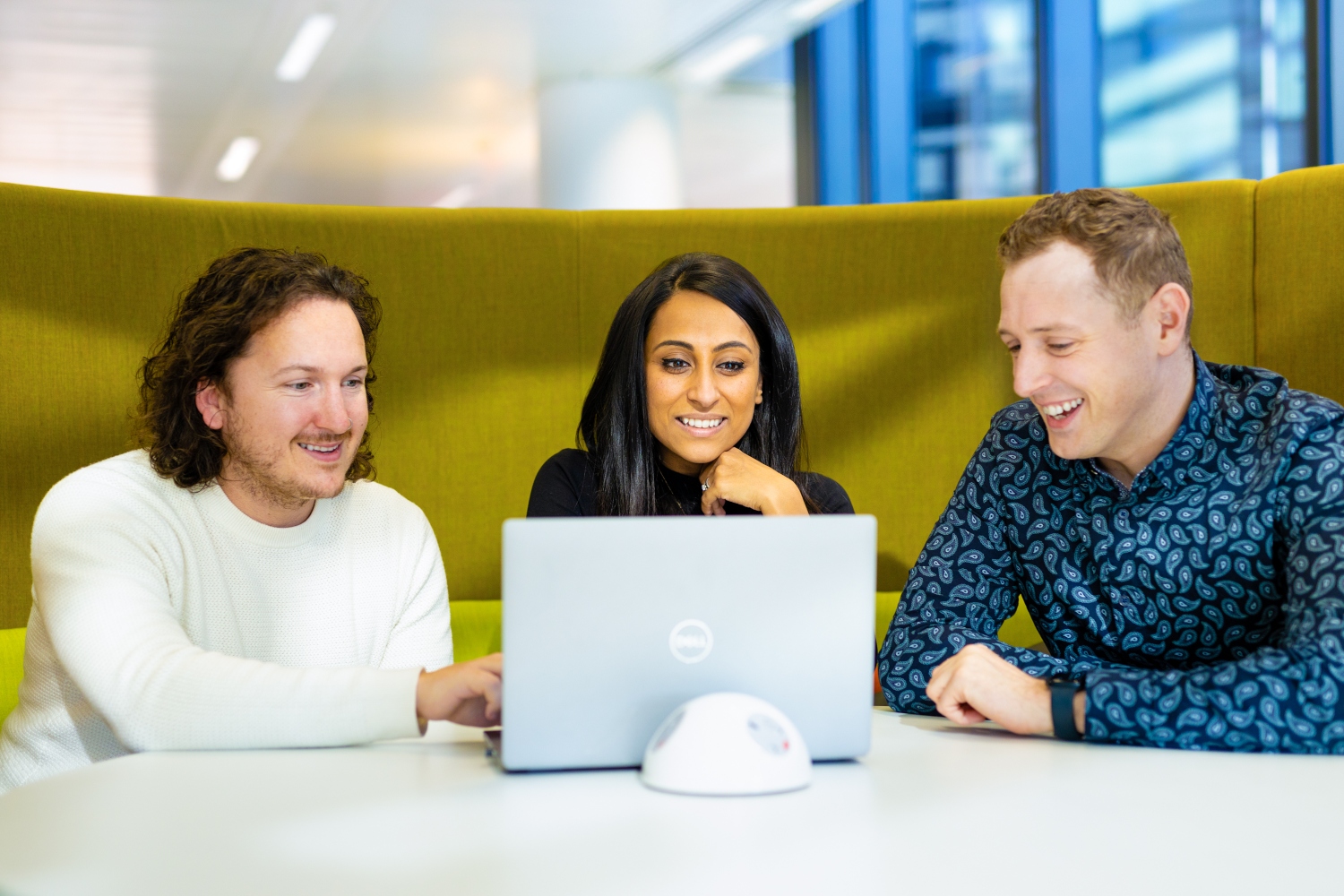 Three people at a laptop