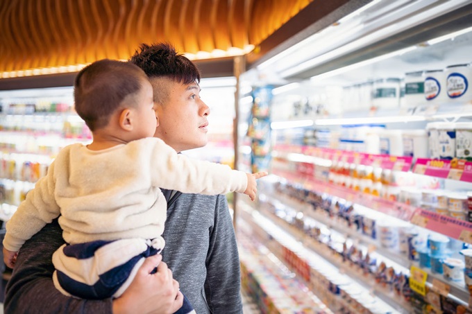 Man with child looking at groceries