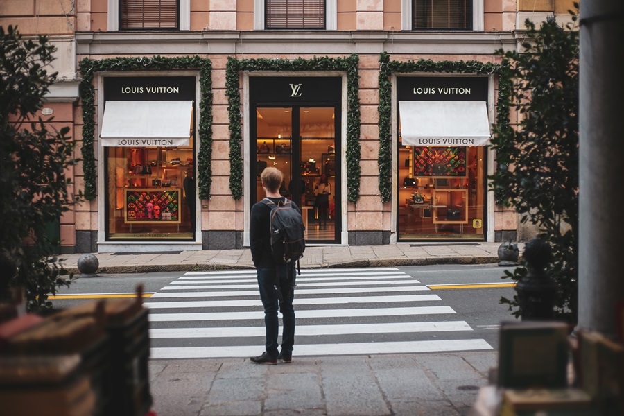 People seen walking past a Louis Vuitton store in the area of