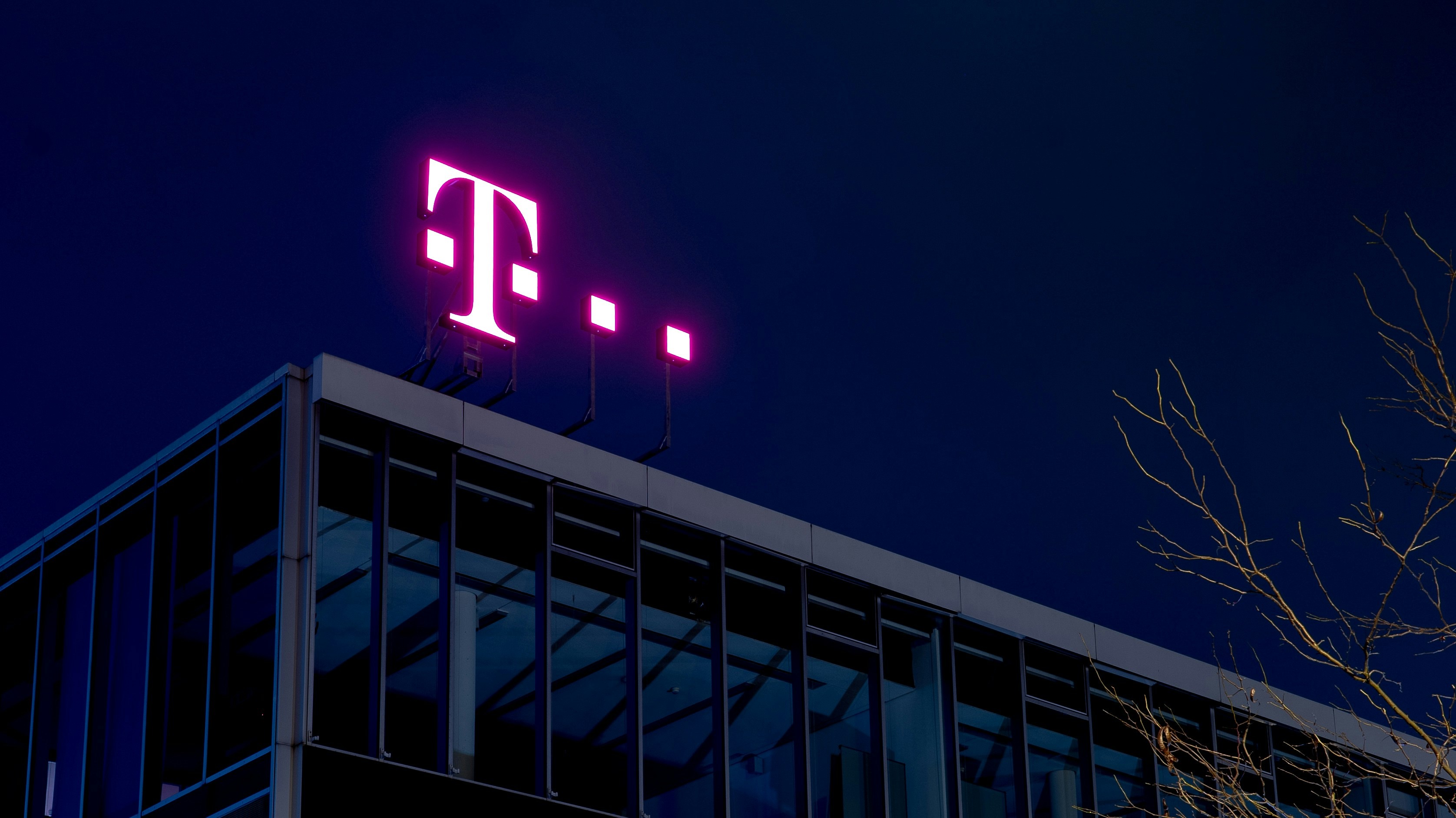 Image of the Telekom brand logo against a night sky at the headquarters in Germany