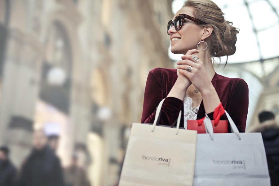 A woman shopping in the street holding lots of bags