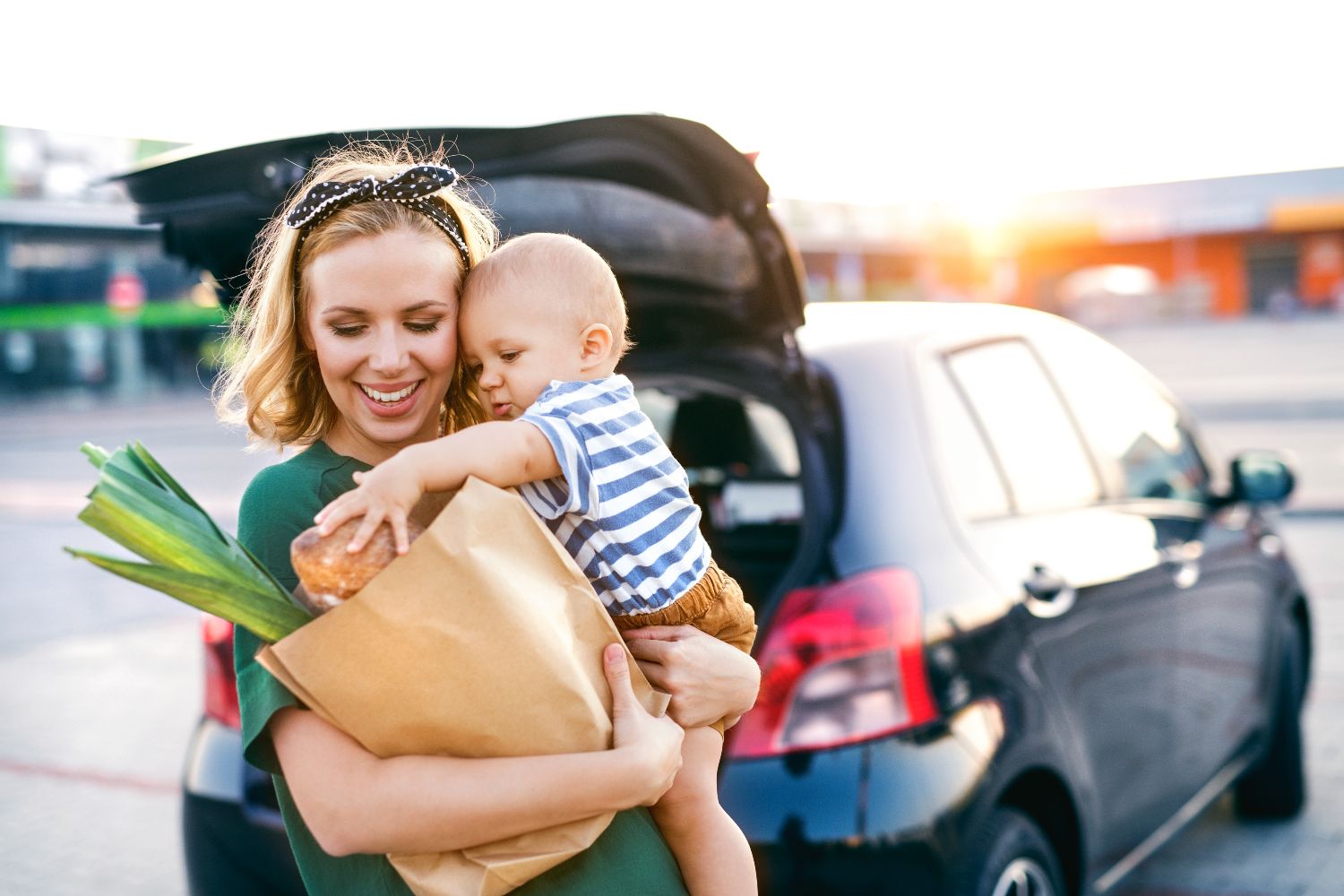 Woman with small child and paper bag with groceries