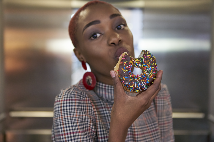 mulher comendo donut chocolate