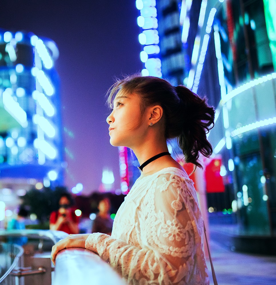 Una mujer observando las luces de los edificios