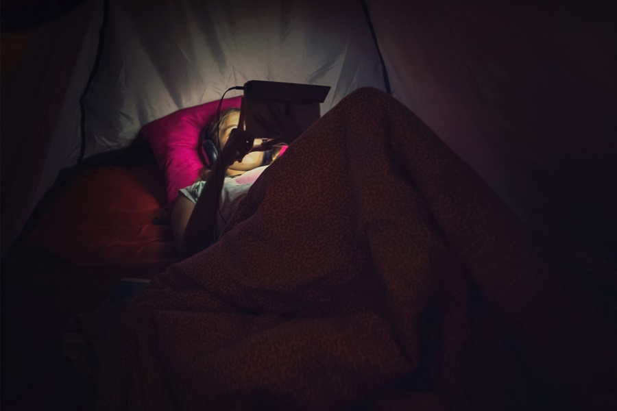 niña mirando su tablet por la noche