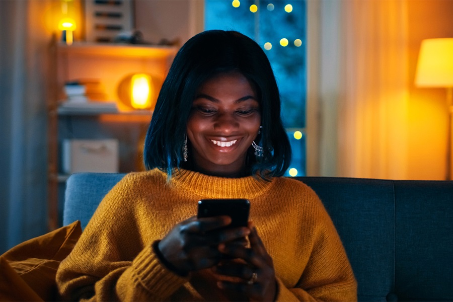 mujer sonriente mirando su móvil
