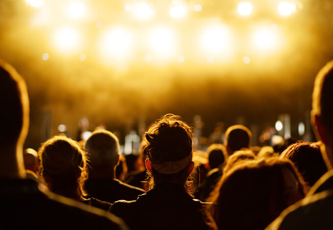 Audience gather under bright stage lights