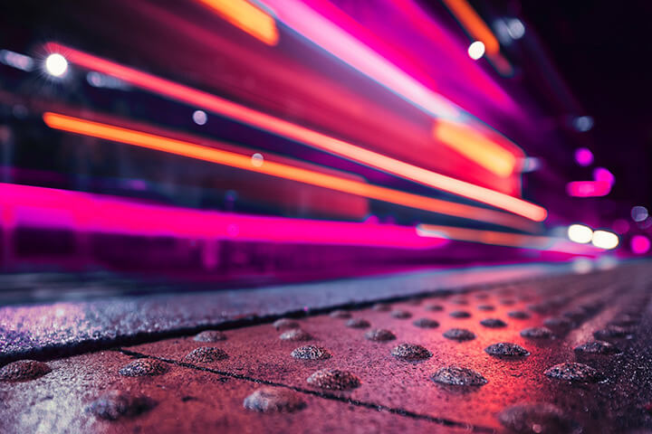 Pink light trails on a sidewalk