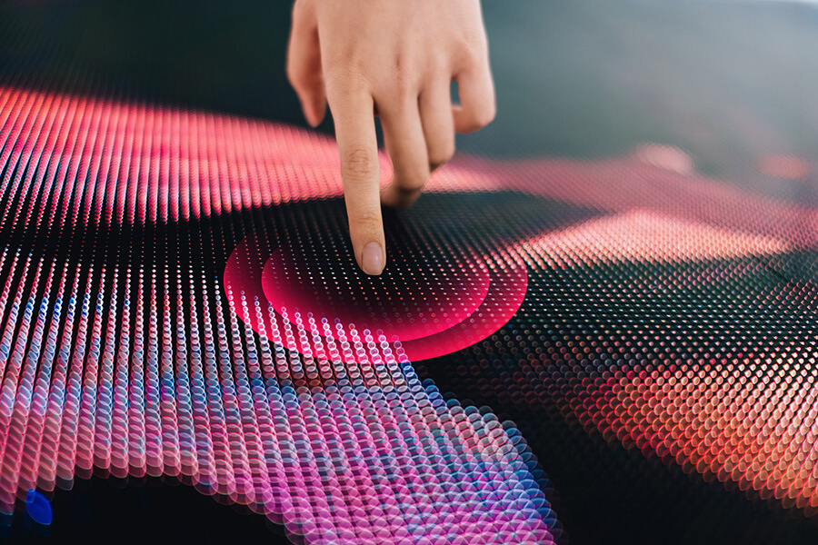 Close up of woman's hand touching illuminated LED display screen