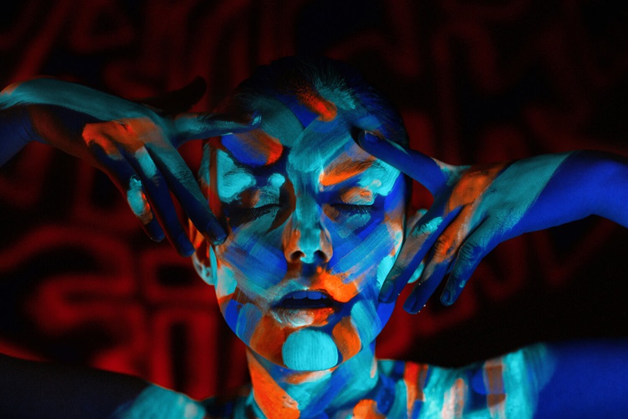 A face covered in neon paints
