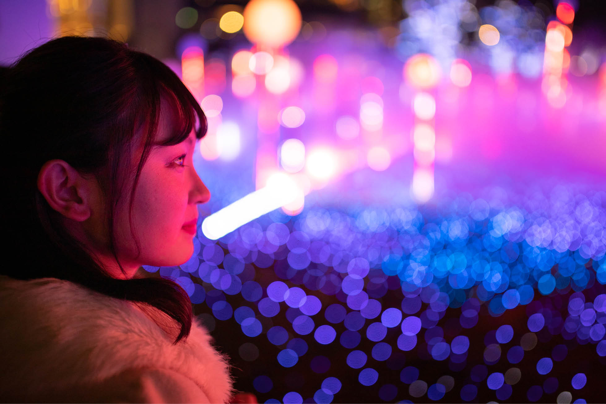 woman looking out over floodlit crowd