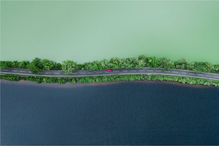 Car moving between dark and light lakes in Scotland