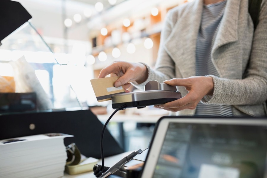 Woman paying with card machine in UK shop