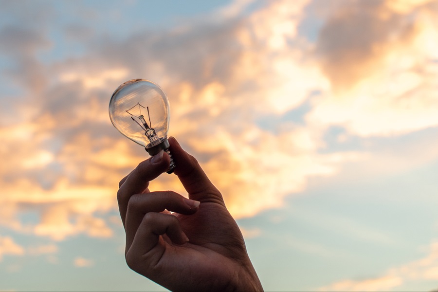 A close up photo of a person holding a clear light bulb