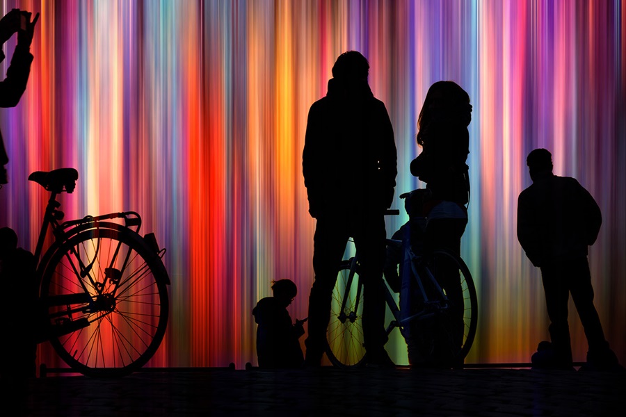 People silhouetted in front of coloured lights