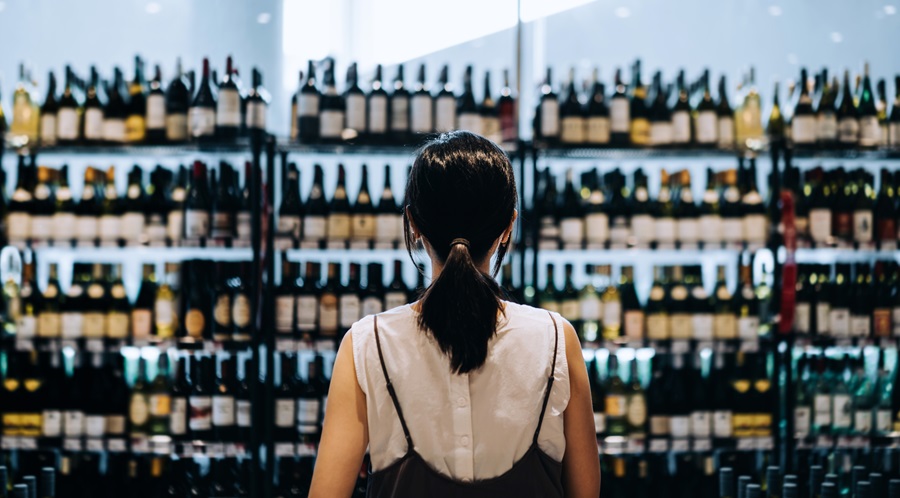 Woman in supermarket browsing alcohol