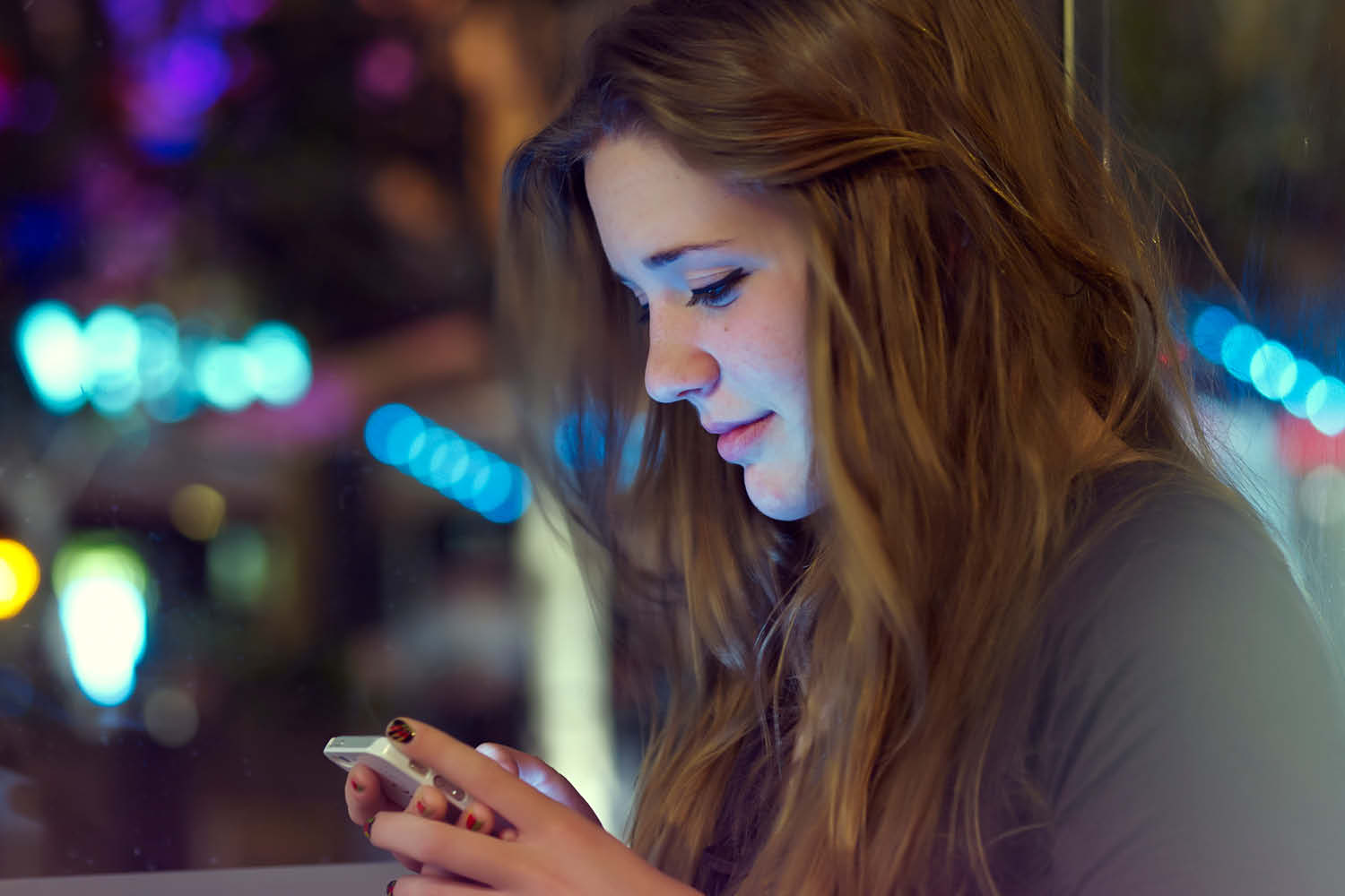 Pretty young businesswoman text messaging on smartphone